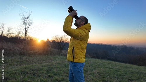 Amateur astronomer observing skies with binoculars.