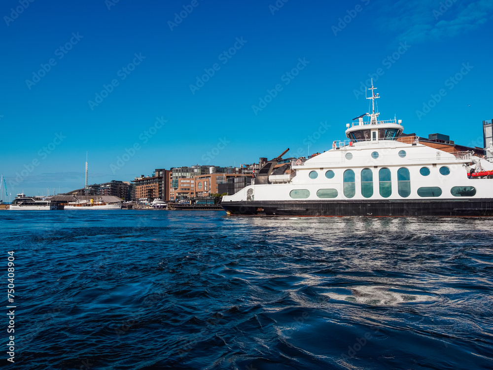 Modern ferry cruising in Oslo fjord and arriving to a city quayside Modern ferry cruising in Oslo fjord and arriving to a city quayside