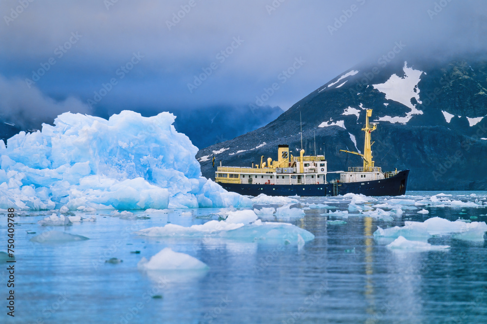 Ship at an iceberg at the coast at Svalbard
