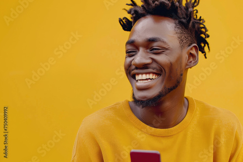 African American woman smiling joyfully and looking at his phone in yellow colors