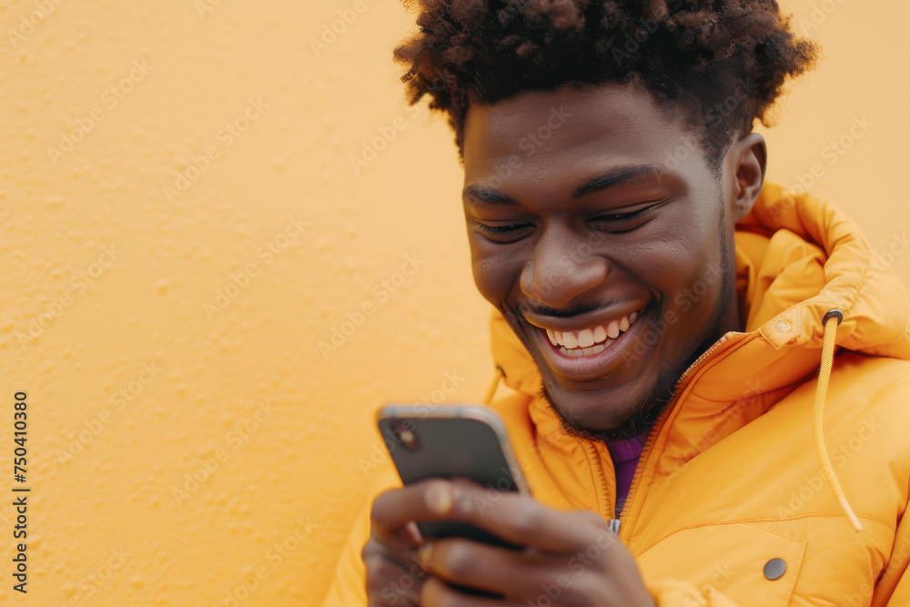 African American woman smiling joyfully and looking at his phone in yellow colors African American woman smiling joyfully and looking at his phone in yellow colors