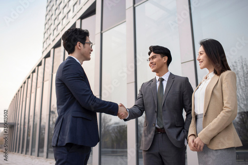 Confident business people shaking hands outdoors
