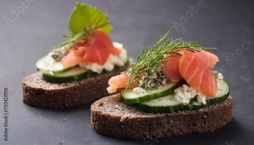 canapes on black bread with cheese, red fish, herbs and cucumber side view
