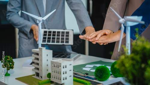 Sustainable business meetings at desks, green energy concepts. People in business suits discussing eco-friendly solutions, solar cells, wind turbines, and promoting net-zero practices.