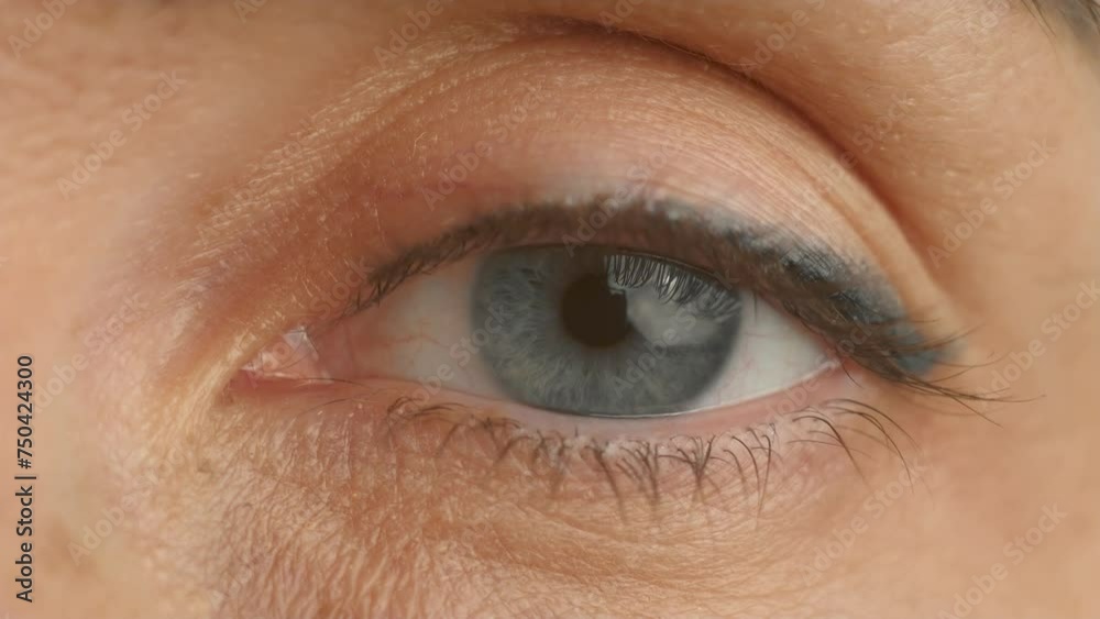 Opening woman left eye close up. Eyelids with eyelashes and facial skin of middle aged female. Human vision, eye pupil and iris, blood vessels, anatomical structure of eyeball macro Opening woman left eye close up. Eyelids with eyelashes and facial skin of middle aged female. Human vision, eye pupil and iris, blood vessels, anatomical structure of eyeball macro