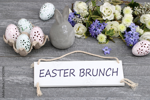 The text Easter Brunch written on a sign with Easter eggs and flowers.