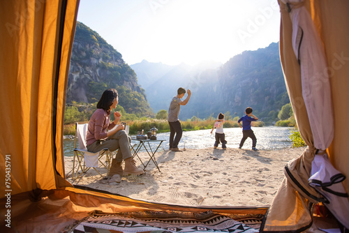 Happy young family camping outdoors photo