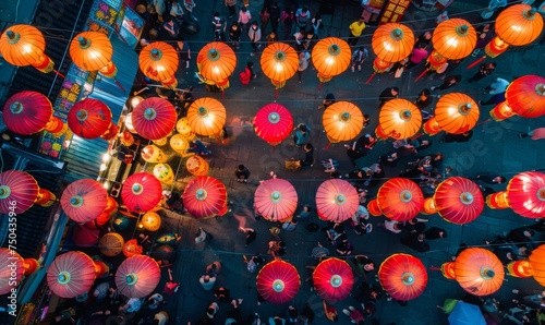 An aerial view of a crowded marketplace or square adorned with rows of hanging Chinese lanterns