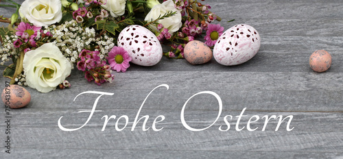 Blumemarrangement mit Ostereiern und dem Text Frohe Ostern.