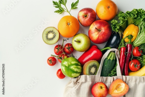 Grocery shopping. Different fresh fruit and vegetables in a textile shopper bag on white background  healthy food from supermarket or delivery concept.