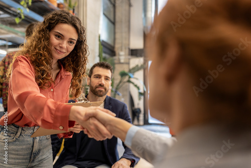 Smiling recruiter doing handshake with candidate at office photo