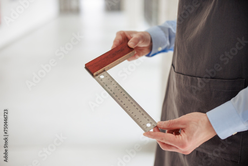 Engineer wearing apron and holding measuring ruler at workshop photo