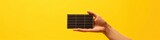 A single solar cell in a human hand against a sunlit yellow background, conveying personal responsibility in energy conservation, perfect for renewable energy campaigns and personal impact messaging