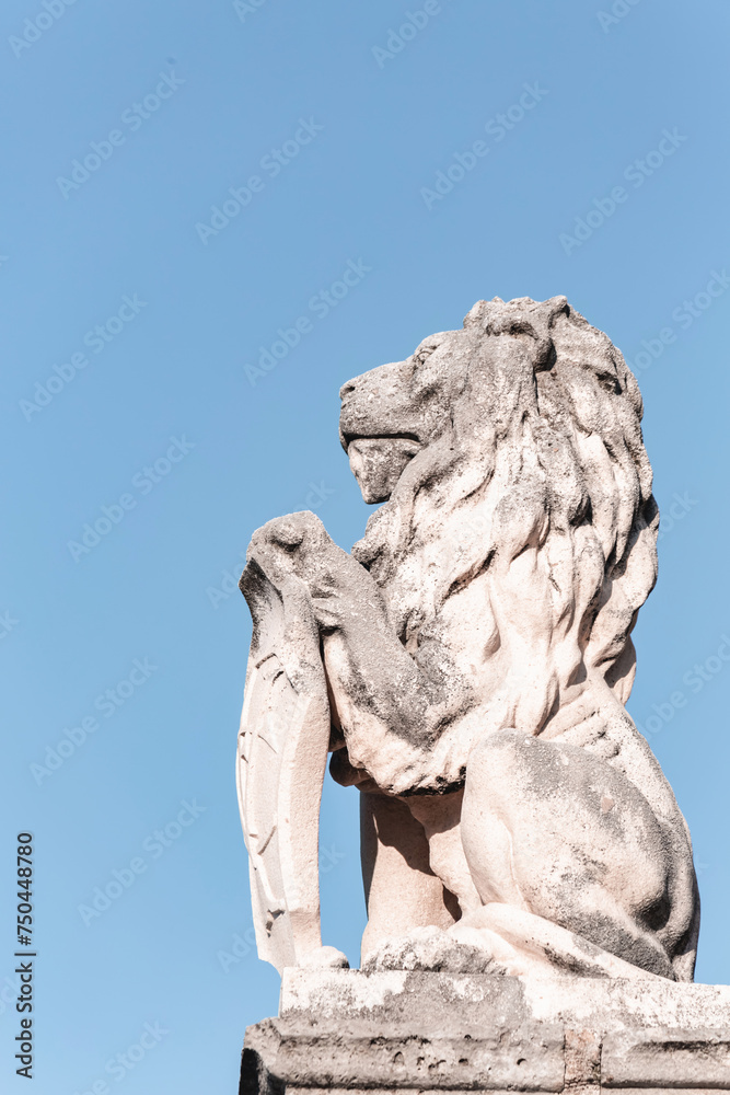 Stone lion statue with heraldic shield. Blue sky background, cover page, copy space. Perast town, Kotor Bay, Montenegro