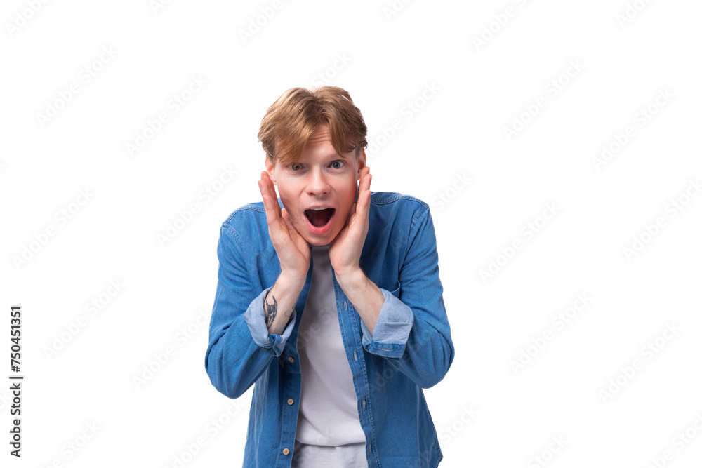 portrait of a surprised caucasian red-haired guy in a denim blue shirt and a white t-shirt portrait of a surprised caucasian red-haired guy in a denim blue shirt and a white t-shirt