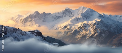 Majestic Snow-Capped Mountain Range Embraced by Low Clouds in Golden Sunrise Light