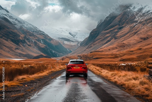 Red car standing on the road near mountains at daytime 