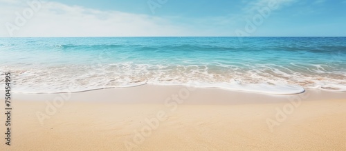 Tranquil Seaside Scene  Sun-Kissed Sandy Beach Embraces Gentle Wave Under Clear Skies
