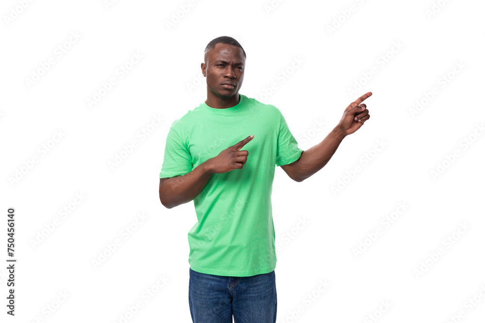 american brunette man with short haircut dressed in a light green t-shirt points his hand to the side advertising space american brunette man with short haircut dressed in a light green t-shirt points his hand to the side advertising space