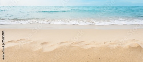 Tranquil Seaside View: Sand Dunes, Ocean Waves under a Clear Blue Sky