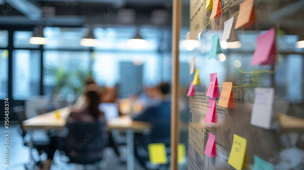 Focused IT project team in a scrum meeting with colorful post-it notes on glass