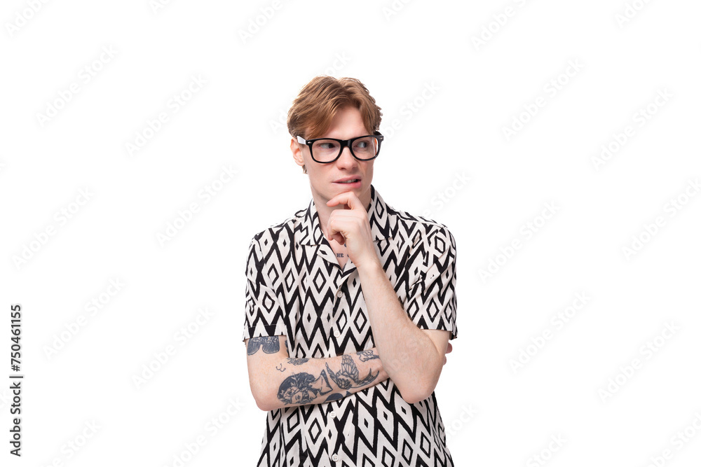 young handsome caucasian man with reddish golden hair in a black and white summer shirt looks attentively to the side young handsome caucasian man with reddish golden hair in a black and white summer shirt looks attentively to the side