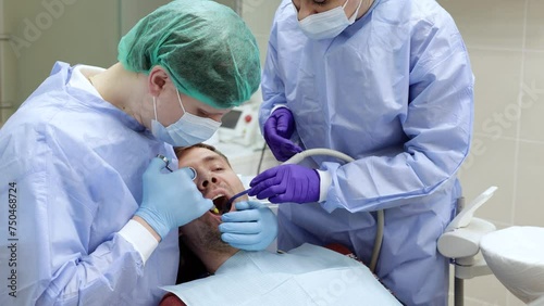 Dentist applies an injection of anesthetic with a syringe in a dental clinic. Dental treatment concept photo