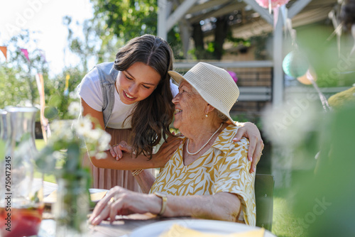 Tableau sur toile Granddaughter and grandmother reunite after at garden party.
