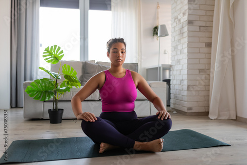Woman resting after home workout, New Year's resolutions, healthy lifestyle, losing weight and selfcare. Concept of morning or evening exercise.