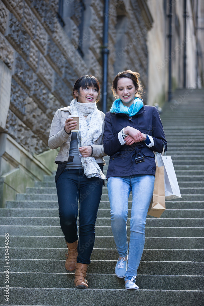 Obraz premium Two happy women shopping together, having fun and laughing