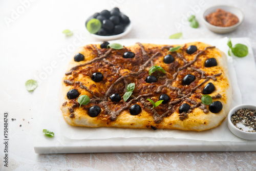 Traditional savory pie with anchovy and olives photo