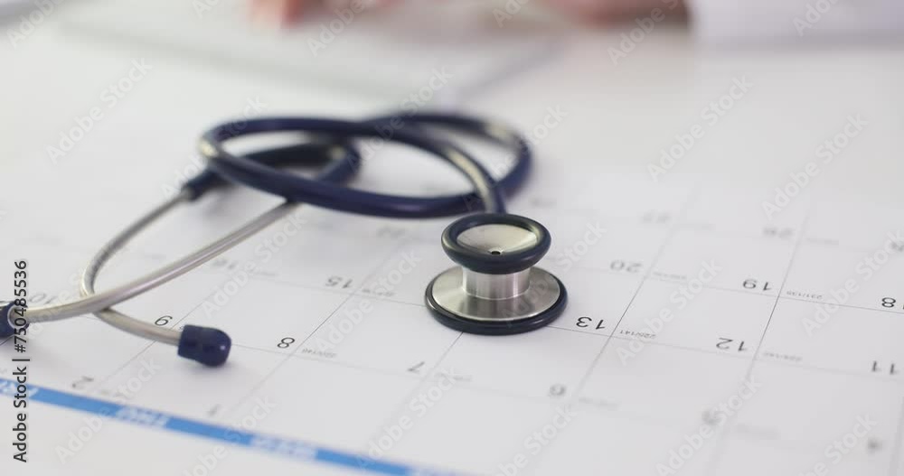 Stethoscope lying on doctor paper calendar in clinic closeup 4k movie slow motion. Annual medical checkup concept Stethoscope lying on doctor paper calendar in clinic closeup 4k movie slow motion. Annual medical checkup concept