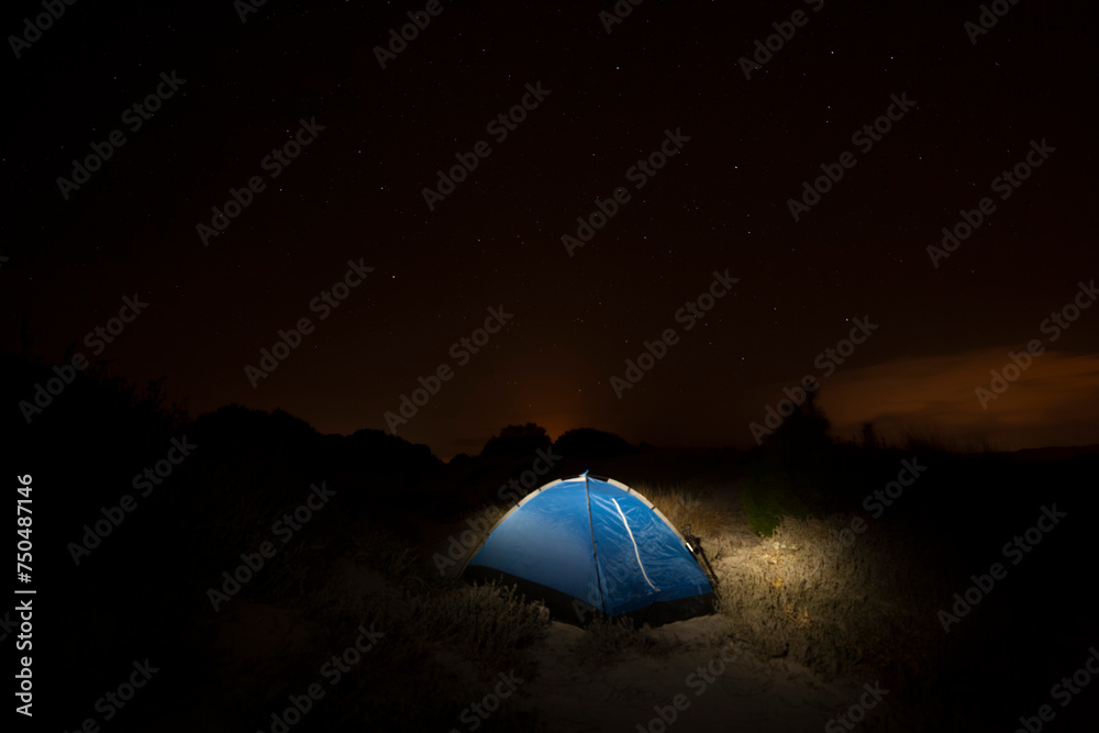 image of photographer at nighttime in a tent under starry sky 