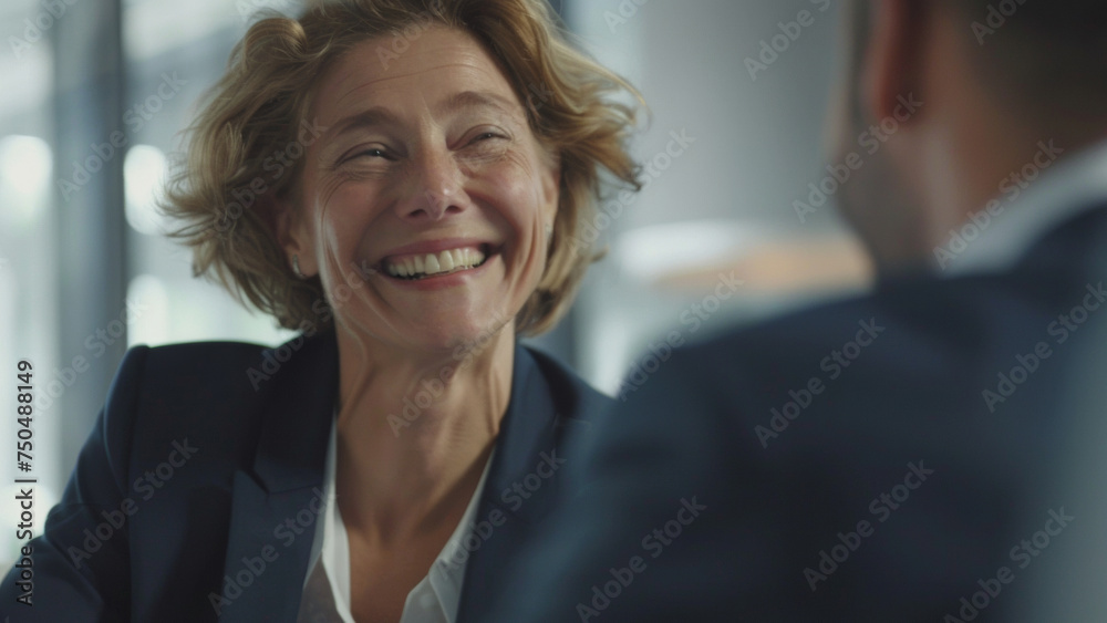 Joyous businesswoman shares laughter during engaging conversation. Joyous businesswoman shares laughter during engaging conversation.