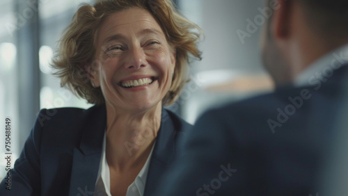 Joyous businesswoman shares laughter during engaging conversation.
