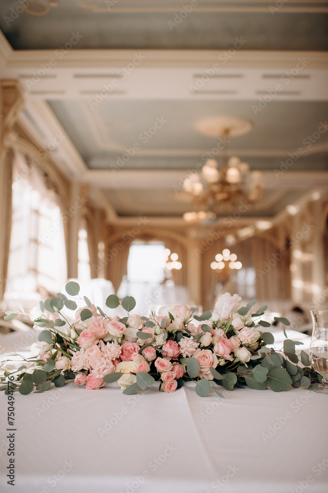 A large flower arrangement of white and pink flowers for the newlyweds' table, decoration of the presidium. On the festive table in the wedding banquet area, compositions of flowers and greenery, cand A large flower arrangement of white and pink flowers for the newlyweds' table, decoration of the presidium. On the festive table in the wedding banquet area, compositions of flowers and greenery, cand