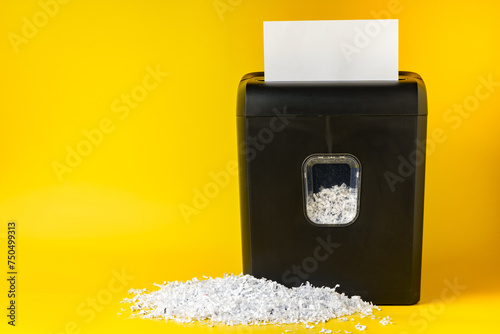 Office paper shredder on yellow studio background photo