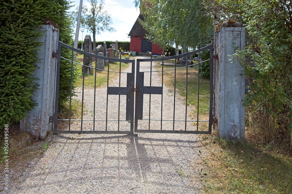 Obraz premium Old wrought iron gate with cross to cemetery.