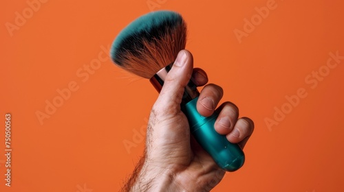 Close-up of a hand holding a soft bristle brush on a vibrant orange background, representing tools in modern male grooming