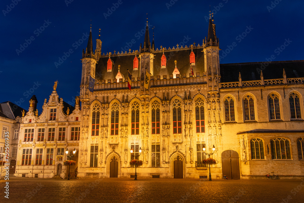 De Burg square and the city hall of the beautiful city of Bruges in Belgium at night, with its historic facades.