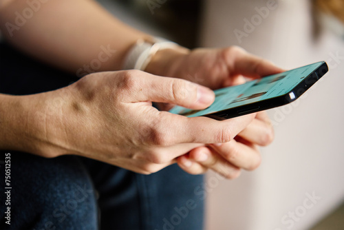 Close-up person casually using smartphone with social media feed displayed on screen, suggesting engagement with digital content. Woman using mobile phone at home
