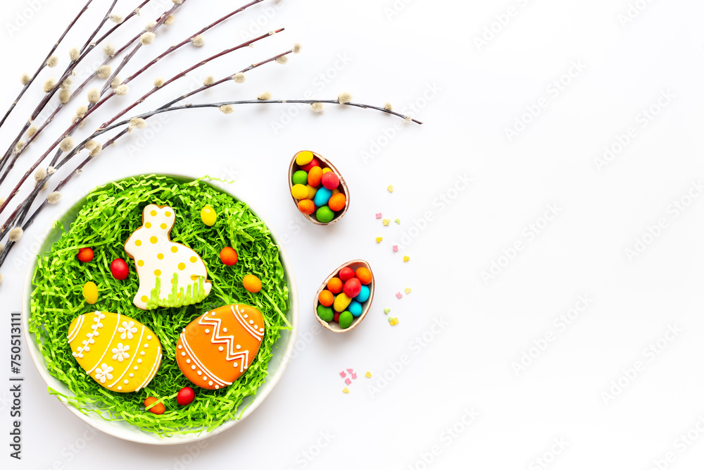 Happy Easter background with eggs and bunny cookies with spring branch, top view