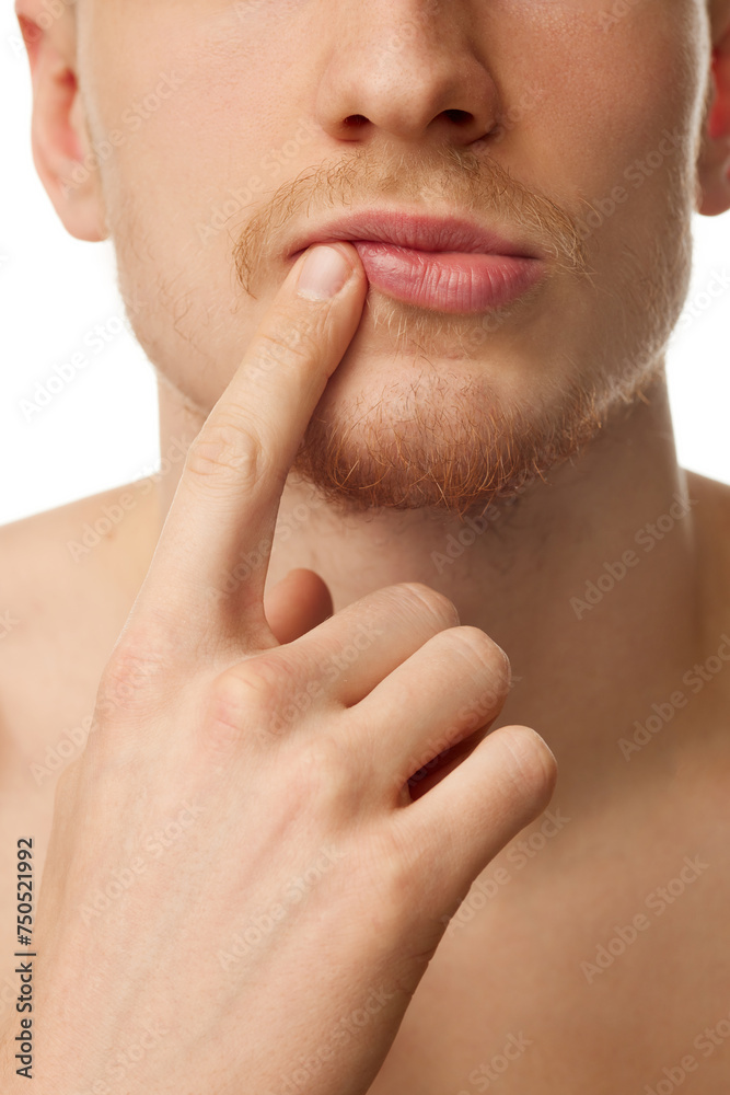 Cropped close-up image of male face, nose, lips. Bearded face. Lip care, face moisturizing. Male model isolated on white studio background. Concept of skin care, male beauty and cosmetics, youth Cropped close-up image of male face, nose, lips. Bearded face. Lip care, face moisturizing. Male model isolated on white studio background. Concept of skin care, male beauty and cosmetics, youth