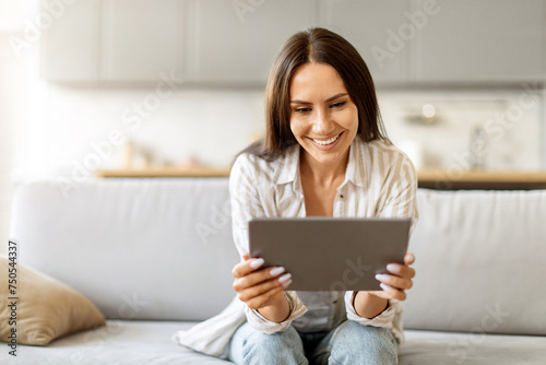 Modern Technologies. Smiling Young Woman Using Digital Tablet At Home