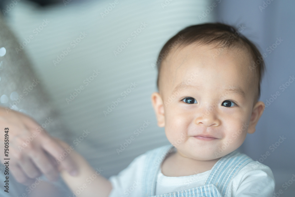 Portrait of enjoy happy love family asian mother playing with adorable little asian baby newborn infant, Mom touching care with cute son in a white bedroom.Love of family concept Portrait of enjoy happy love family asian mother playing with adorable little asian baby newborn infant, Mom touching care with cute son in a white bedroom.Love of family concept