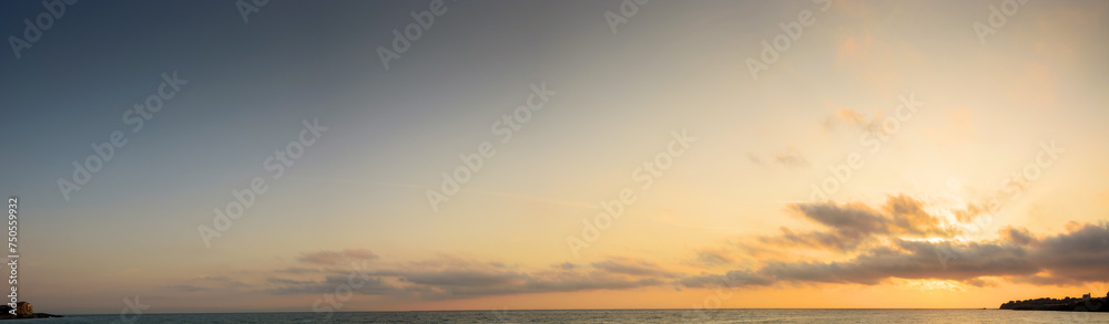 panorama of a golden sunrise at the black sea. fluffy clouds cover the sun above horizon. good weather forecast on summer vacation