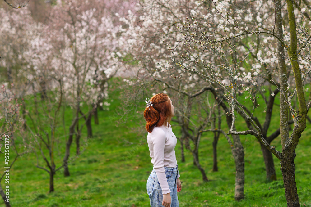 Waiting for Spring. Beautiful romantic red haired girl standing in blooming garden. Waiting for Spring. Beautiful romantic red haired girl standing in blooming garden.