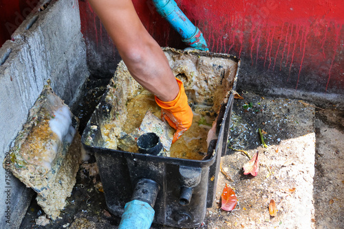 Grease traps from dirty debris being cleaned with a scoop are discarded. How to treat water with a grease trap.