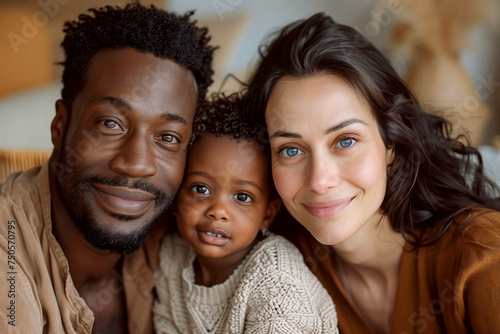 Loving Interracial Family with Toddler Sharing a Warm Embrace looking at camera at Home