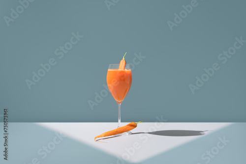 Fresh carrot juice in a glass with carrot garnish photo